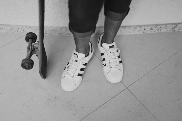 Close-up of athletic shoes on a textured floor.