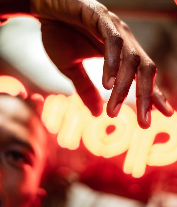 Person in a dynamic pose against a dark background with light trails.